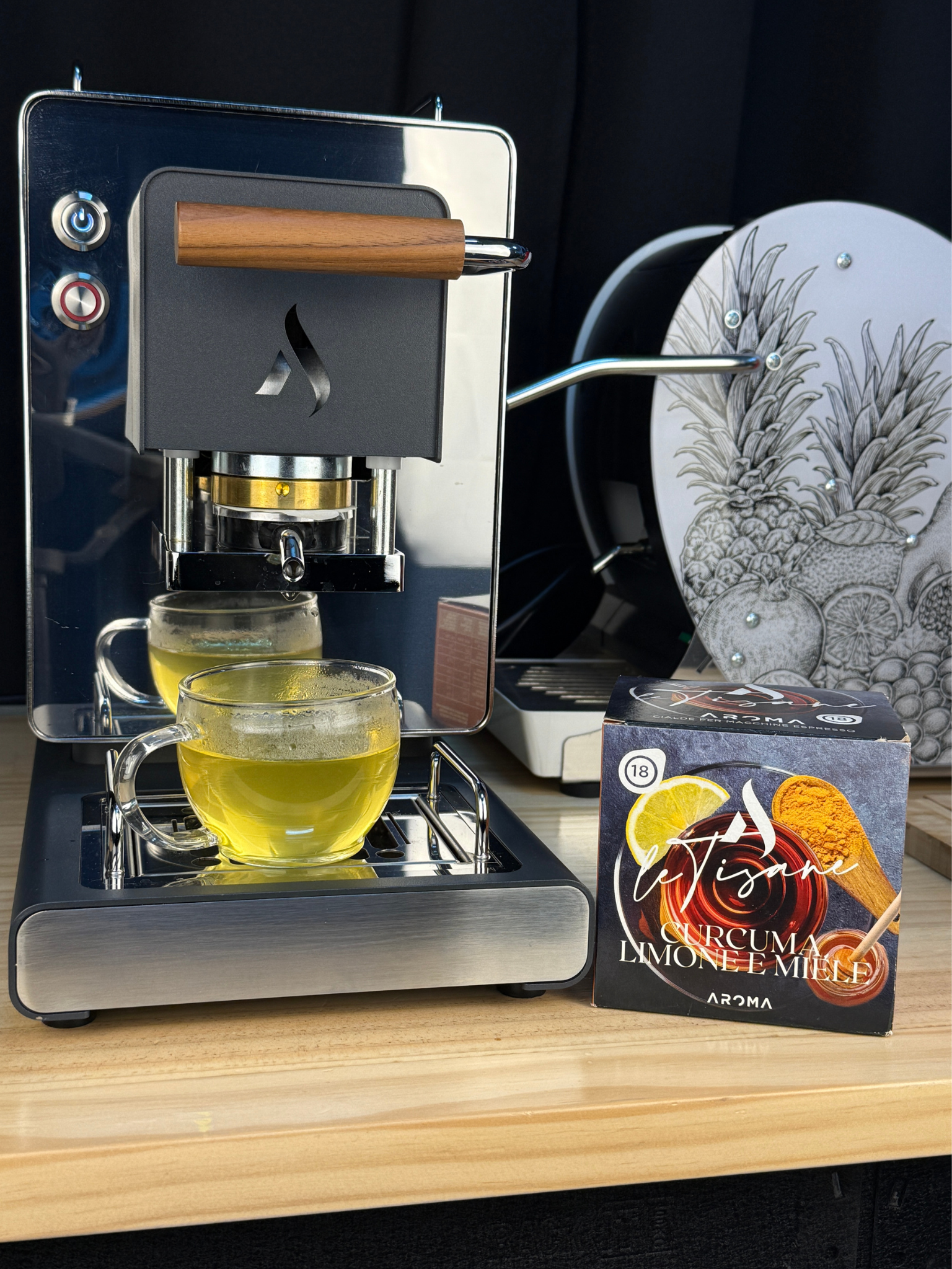 Turmeric Lemon Honey ESE pods box beside a machine and a cup of yellow tea
