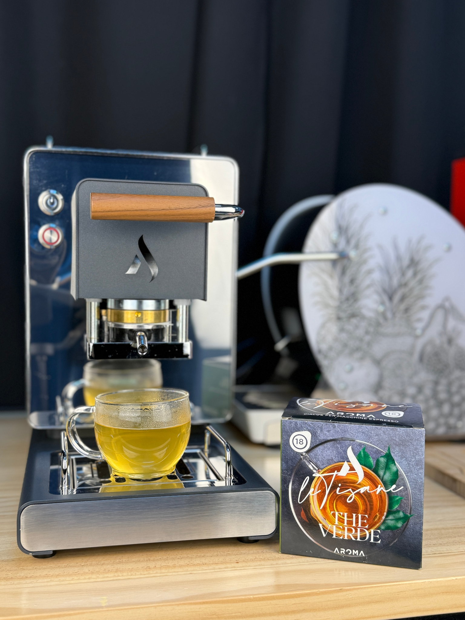 Green herbal tea ESE pod box beside espresso machine and a cup of green tea
