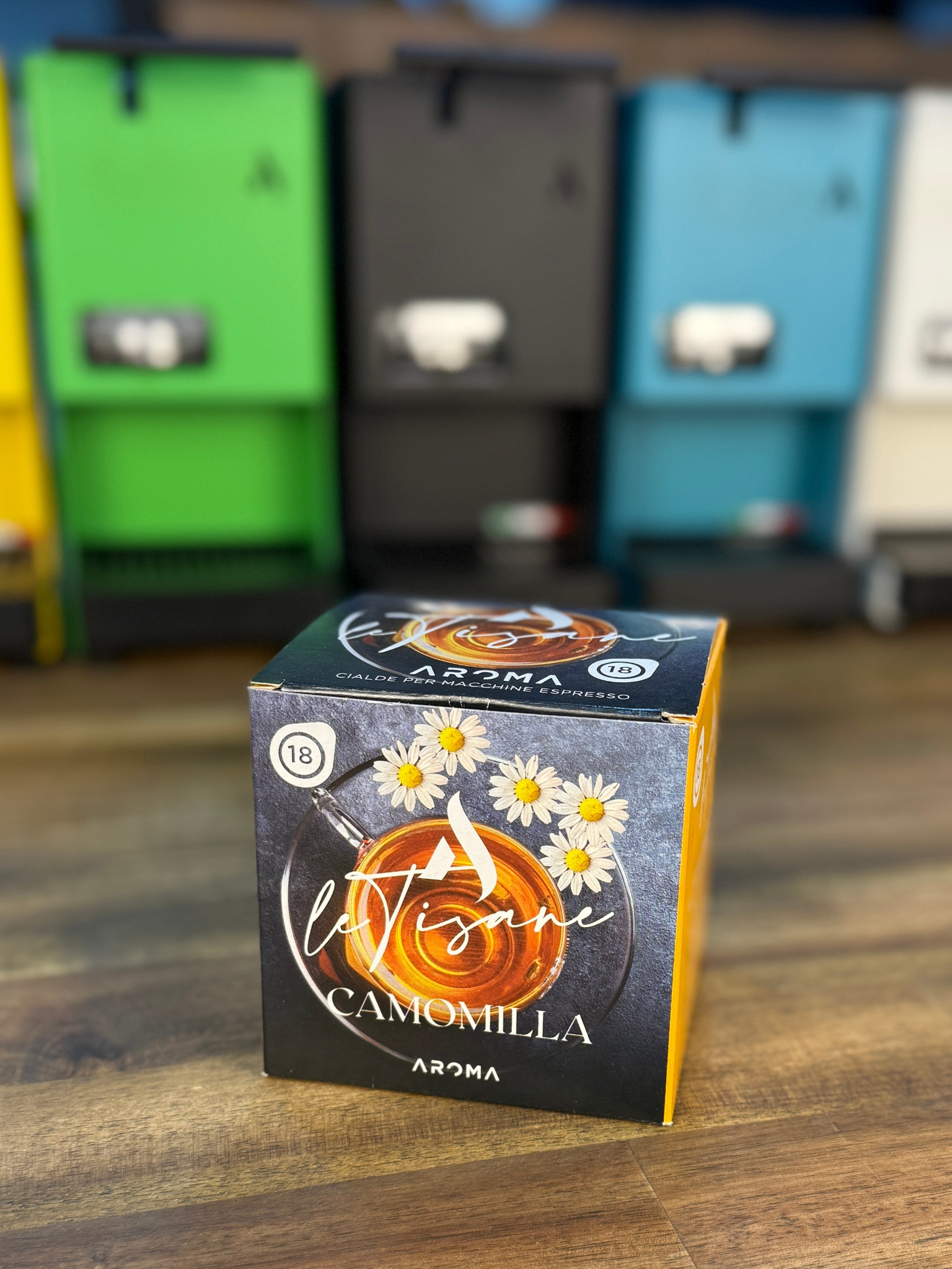 Camomilla aroma ESE tea pods box on tabletop, front face with daisies and 'CAMOMILLA' text