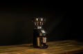 Black coffee grinder with metal hopper and base, front view