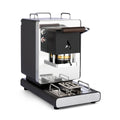 Black coffee pod machine with wooden handle, front brew chamber, and metal drip tray