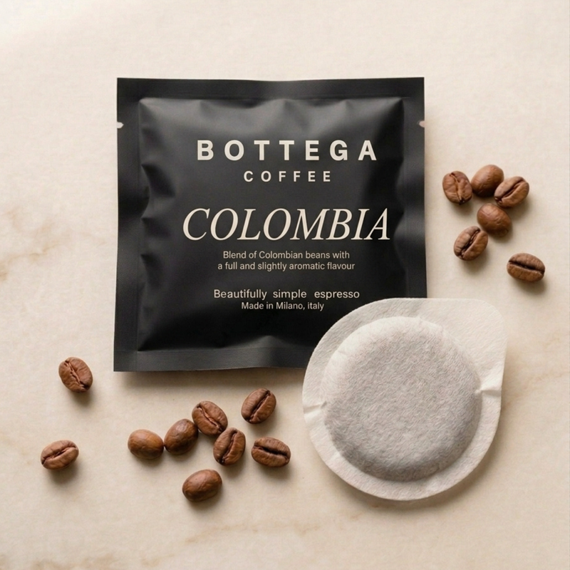 Coffee pod with white circular filter, surrounded by roasted coffee beans