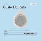 Unwrapped Gusto Delicato coffee pod with visible ground coffee surface