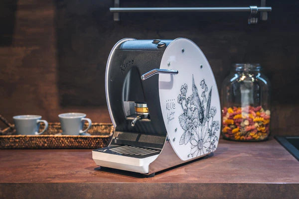 Aroma Kicco ESE coffee pod machine on counter, illustrated white side panel, open brewing head