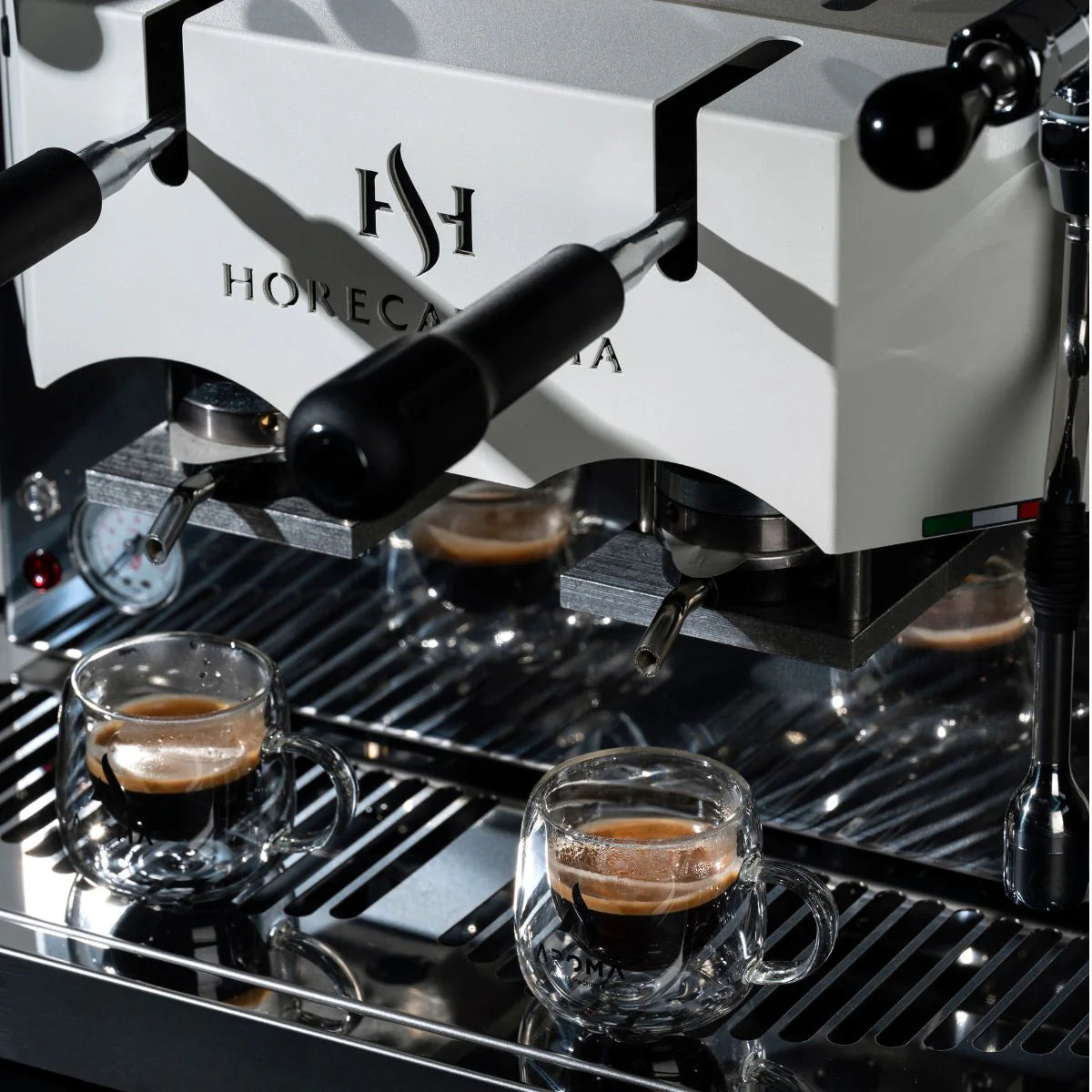Professional pod coffee machine detail with two cups on the drip tray